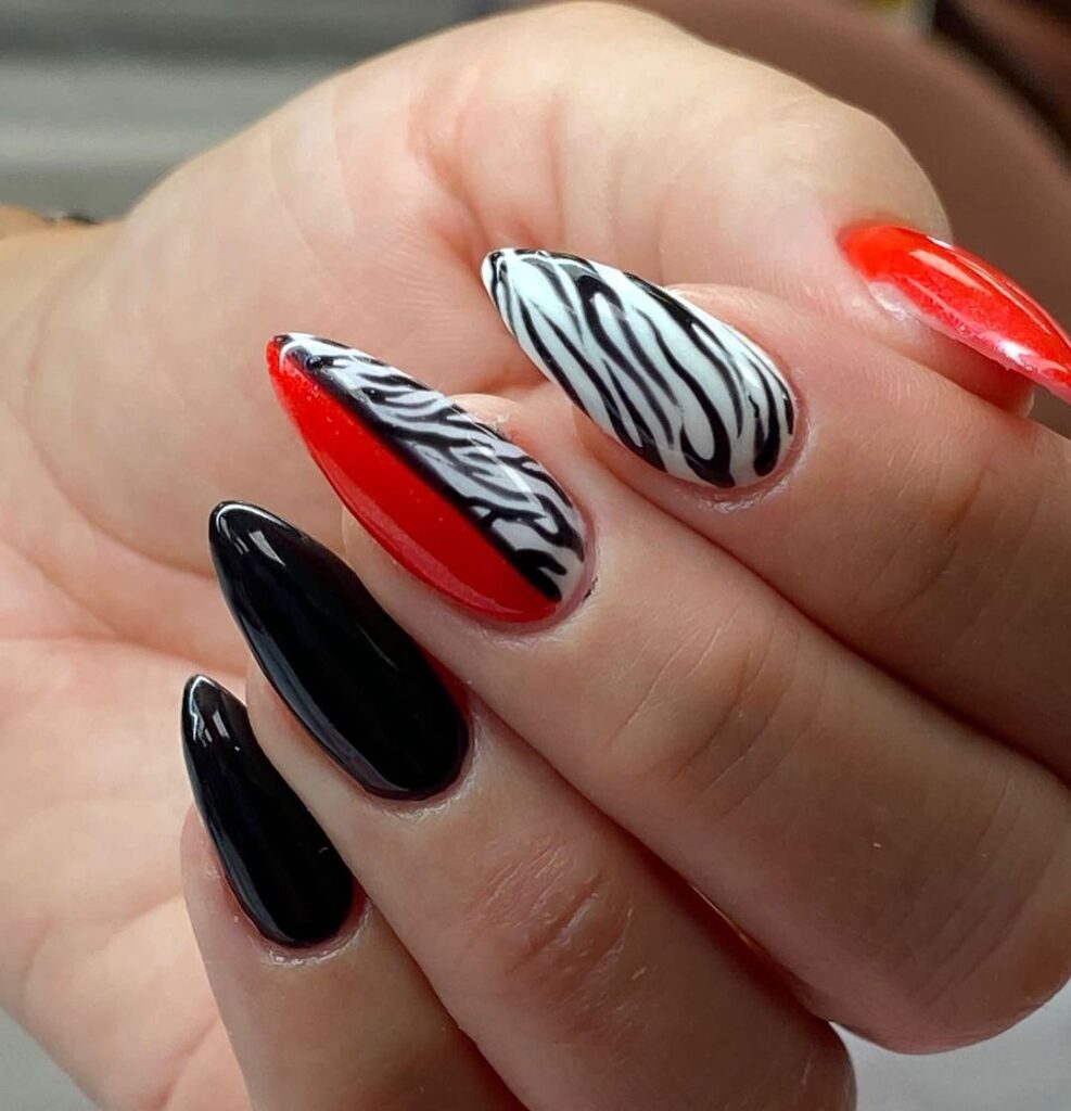 Bold red acrylic nails with black lace patterns