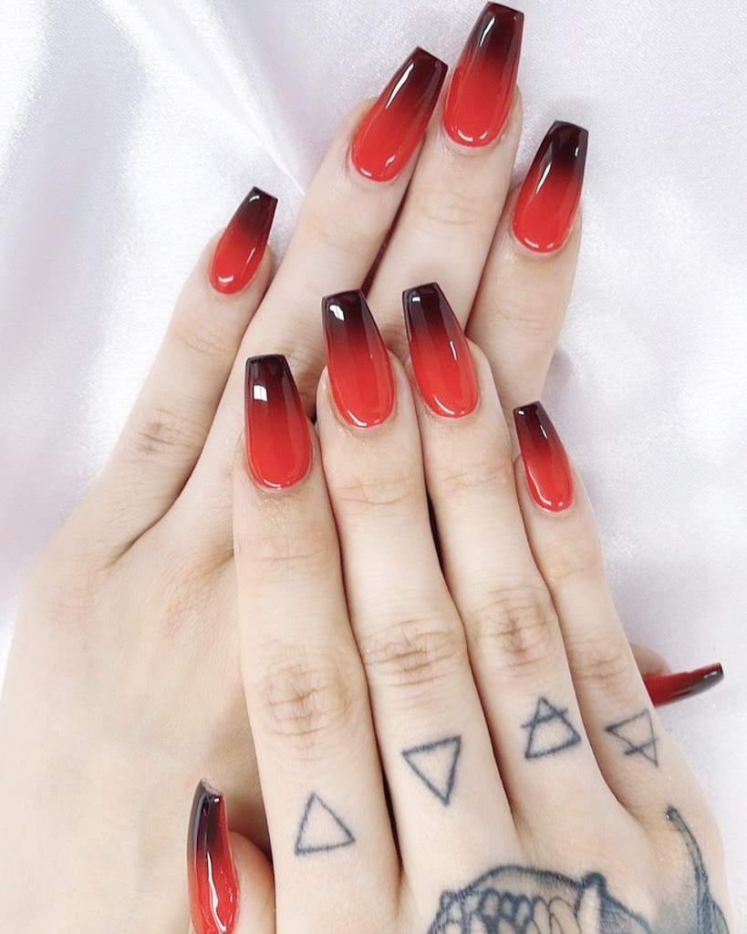 Round nails with a red to black ombre effect.