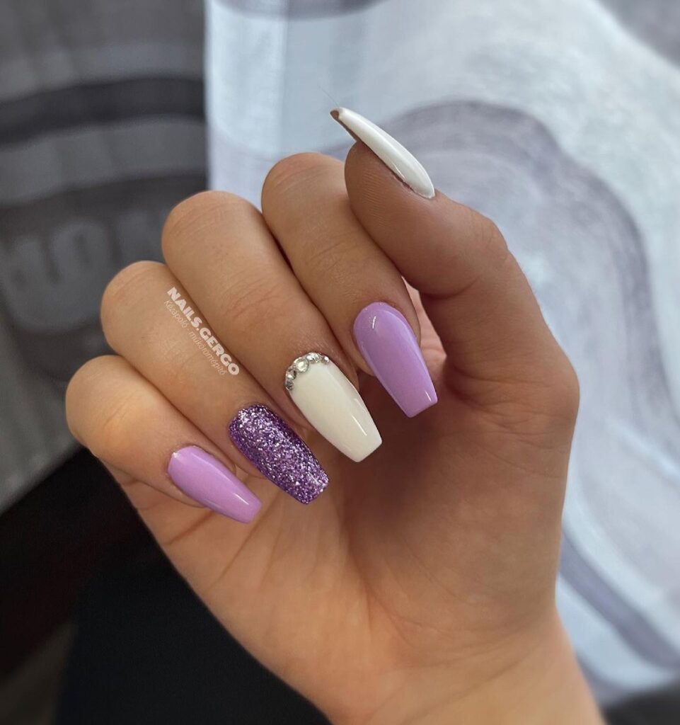 Oval nails with delicate pastel spring flower paintings under gel topcoat