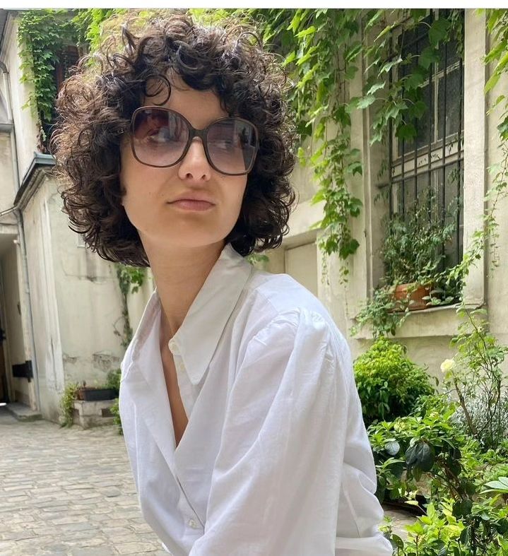 Woman with glasses sporting feathered haircut