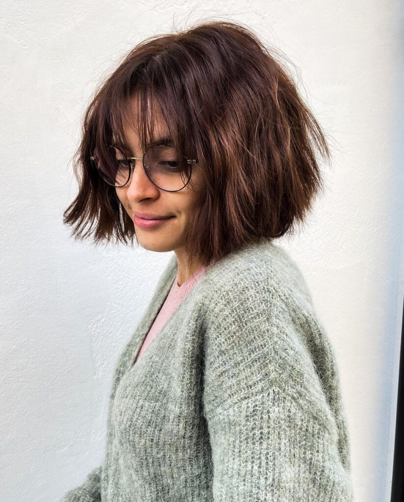 Chin-length waves, straight bangs, glasses-friendly