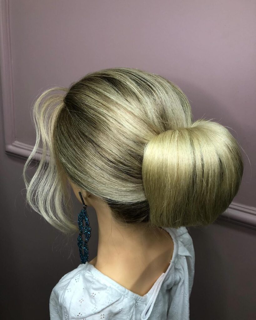 Blonde rolled chignon with blue earrings