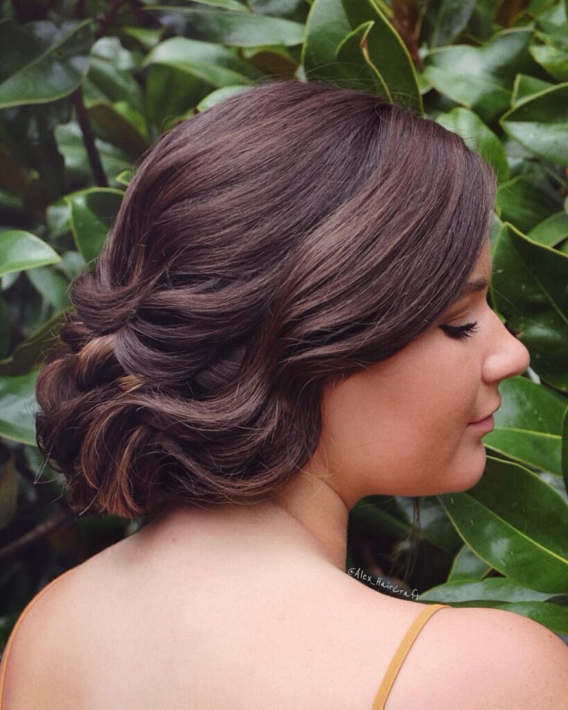 Wavy low bun with loose tendrils