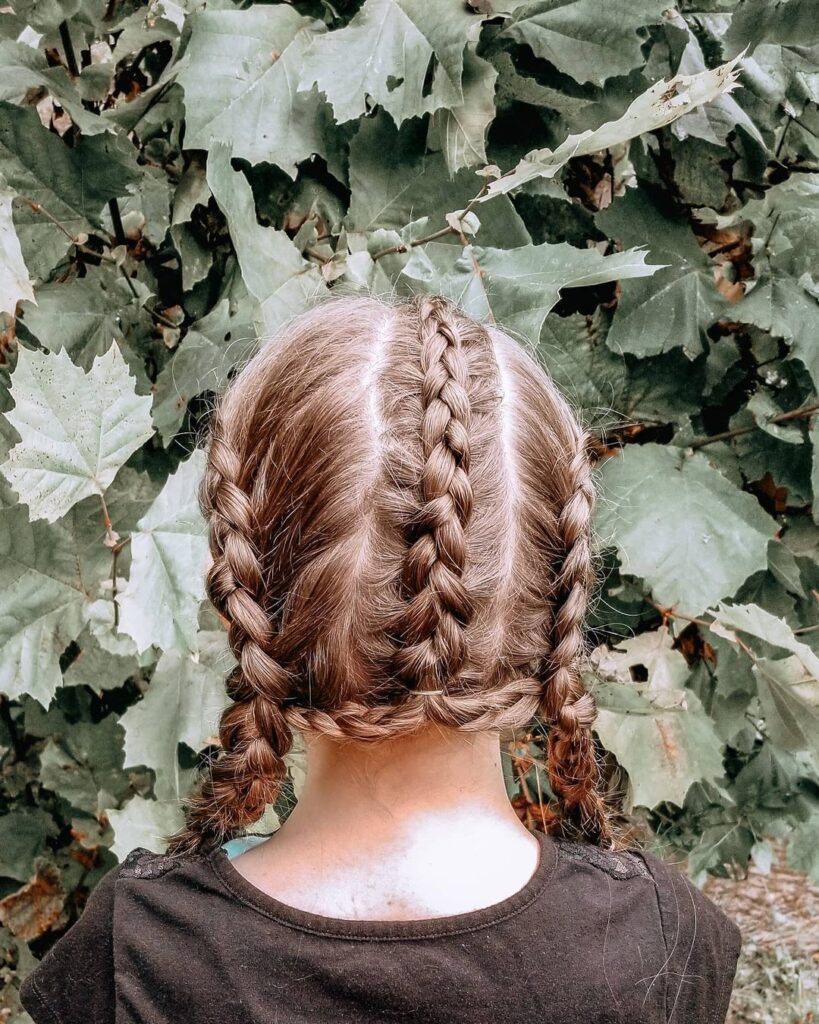 Three Dutch braids, pigtails, neat school hairstyle